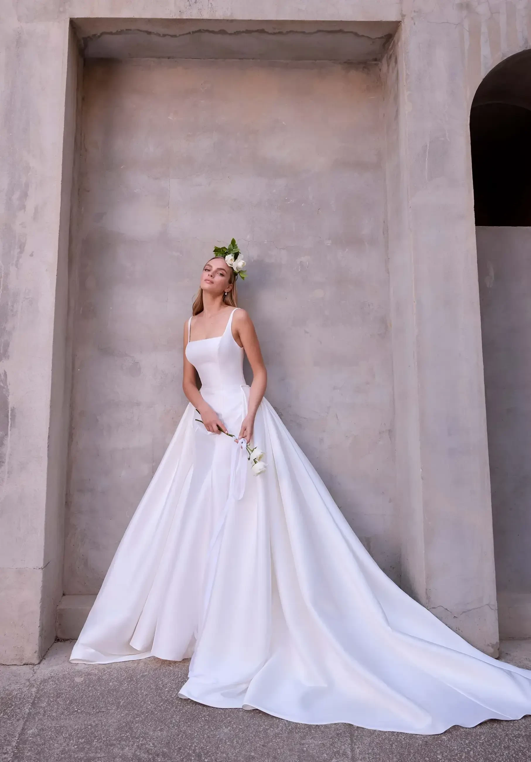 model is wearing s fit and flare wedding dress with a detachable overskirt