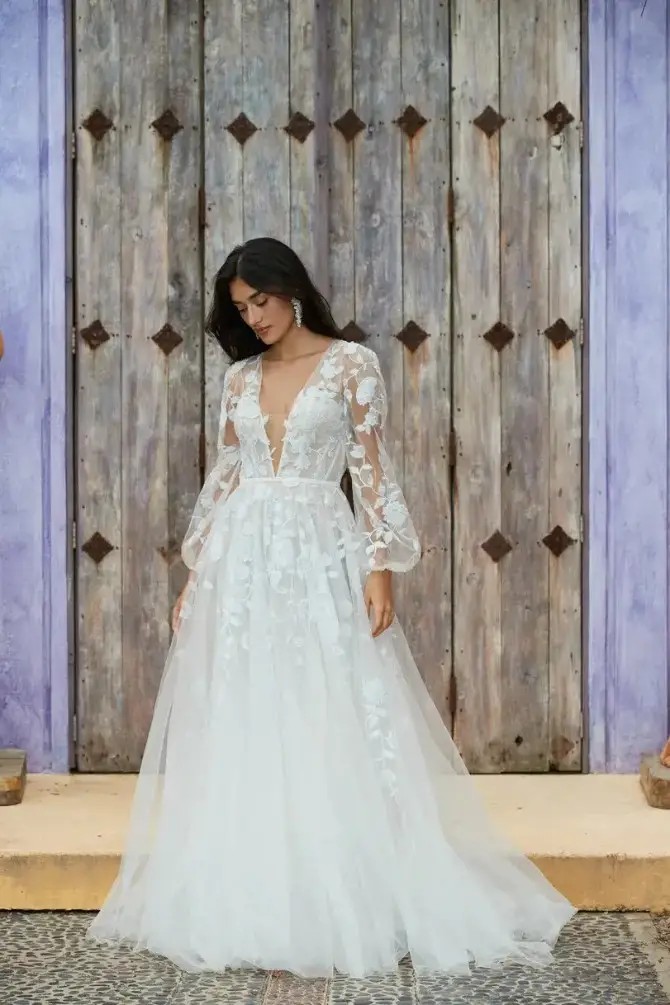 model is wearing a long sleeve wedding dress