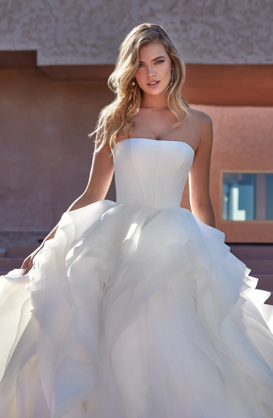 model is wearing a strapless ball gown 