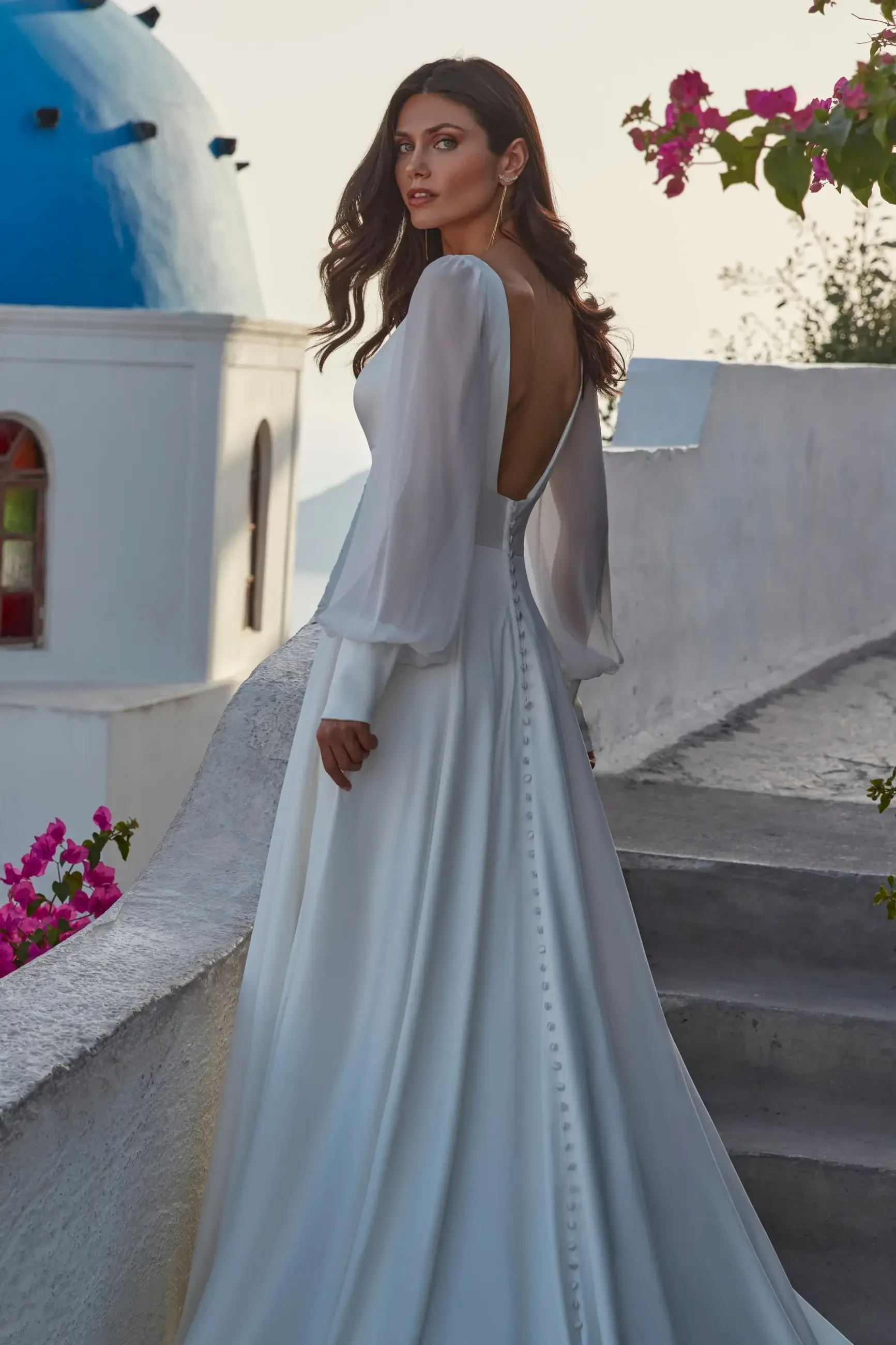 model is wearing a plunging neckline long sleeve wedding dress