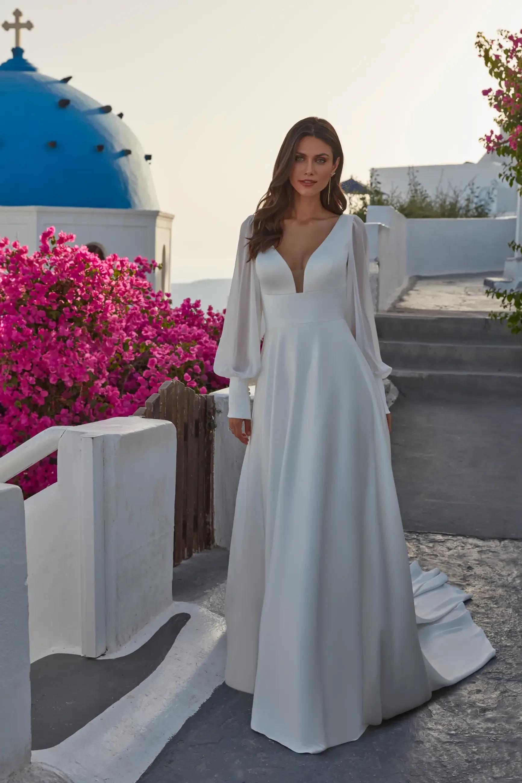model is wearing a plunging neckline long sleeve wedding dress