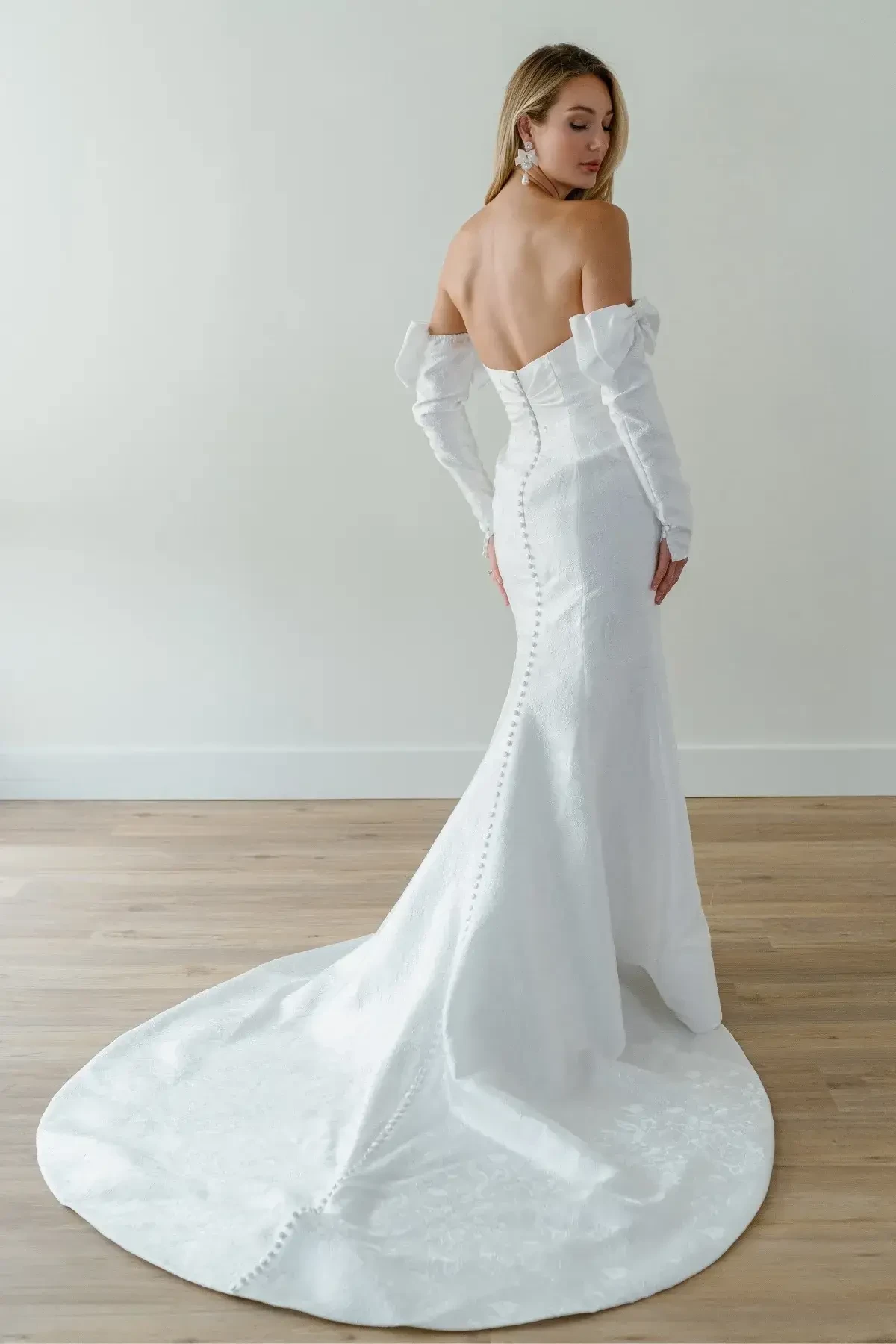 model is wearing an off the shoulder fit and flare wedding dress