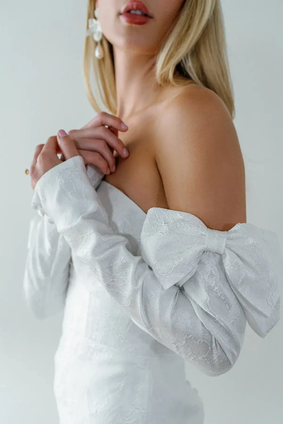 model is wearing an off the shoulder fit and flare wedding dress